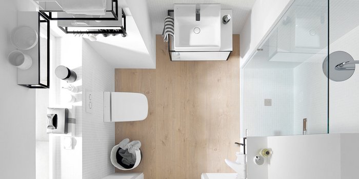 Ein modernes Badezimmer mit einem eleganten Waschbecken, Holzfußboden und einer gläsernen Duschkabine, die viel Licht reflektiert.